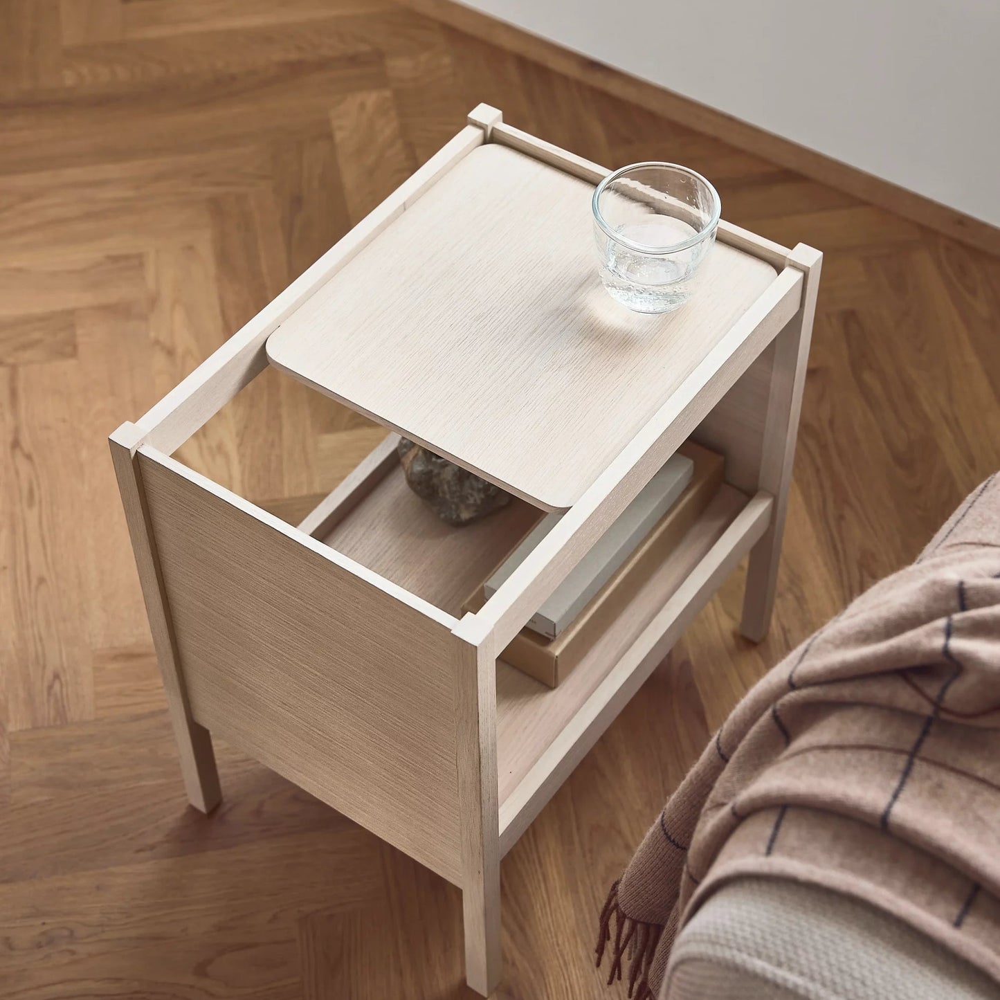 Wooden side table with a glass on a wooden floor