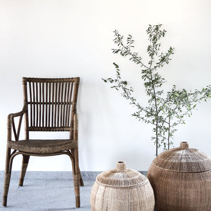 Wicker chair and decorative pots with a plant on a white floor and wall